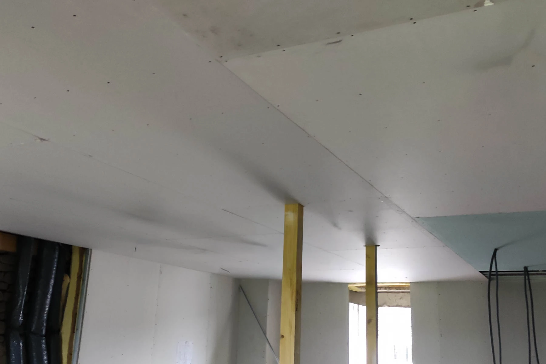 Pose de plaques de plâtre sur ossature et étais de maintien pour la création d'un faux plafond par un artisan plaquiste à Nancy