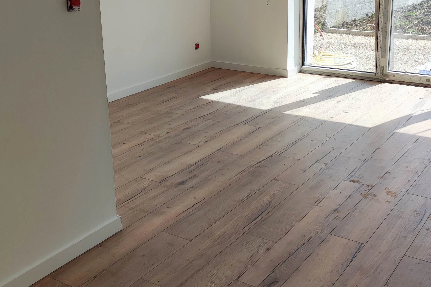 Pose de parquet bois clair dans un couloir et entrée de maison par un artisan à Nancy
