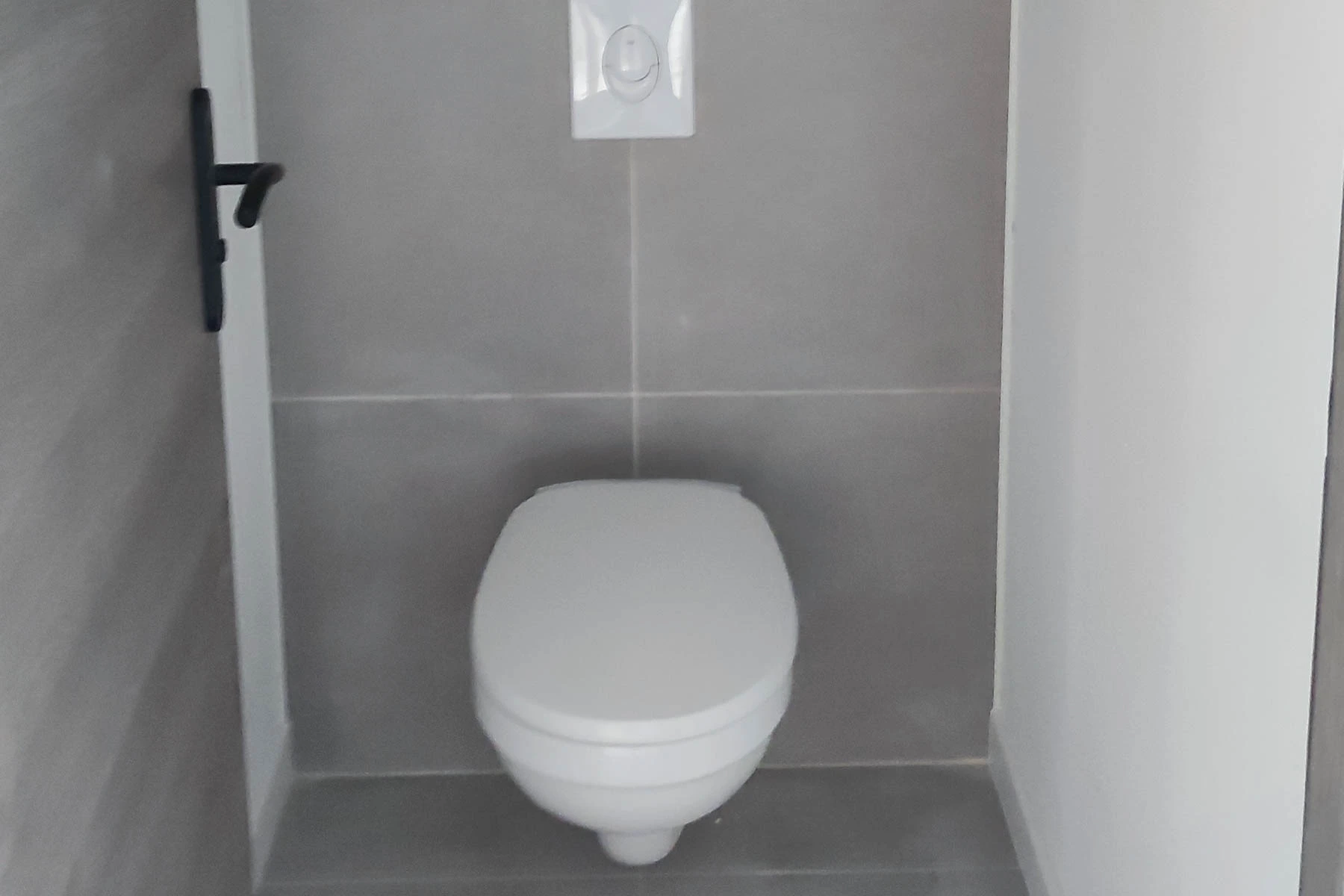 Installation d'un WC suspendu avec carrelage gris moderne dans une salle de bain rénovée à Nancy