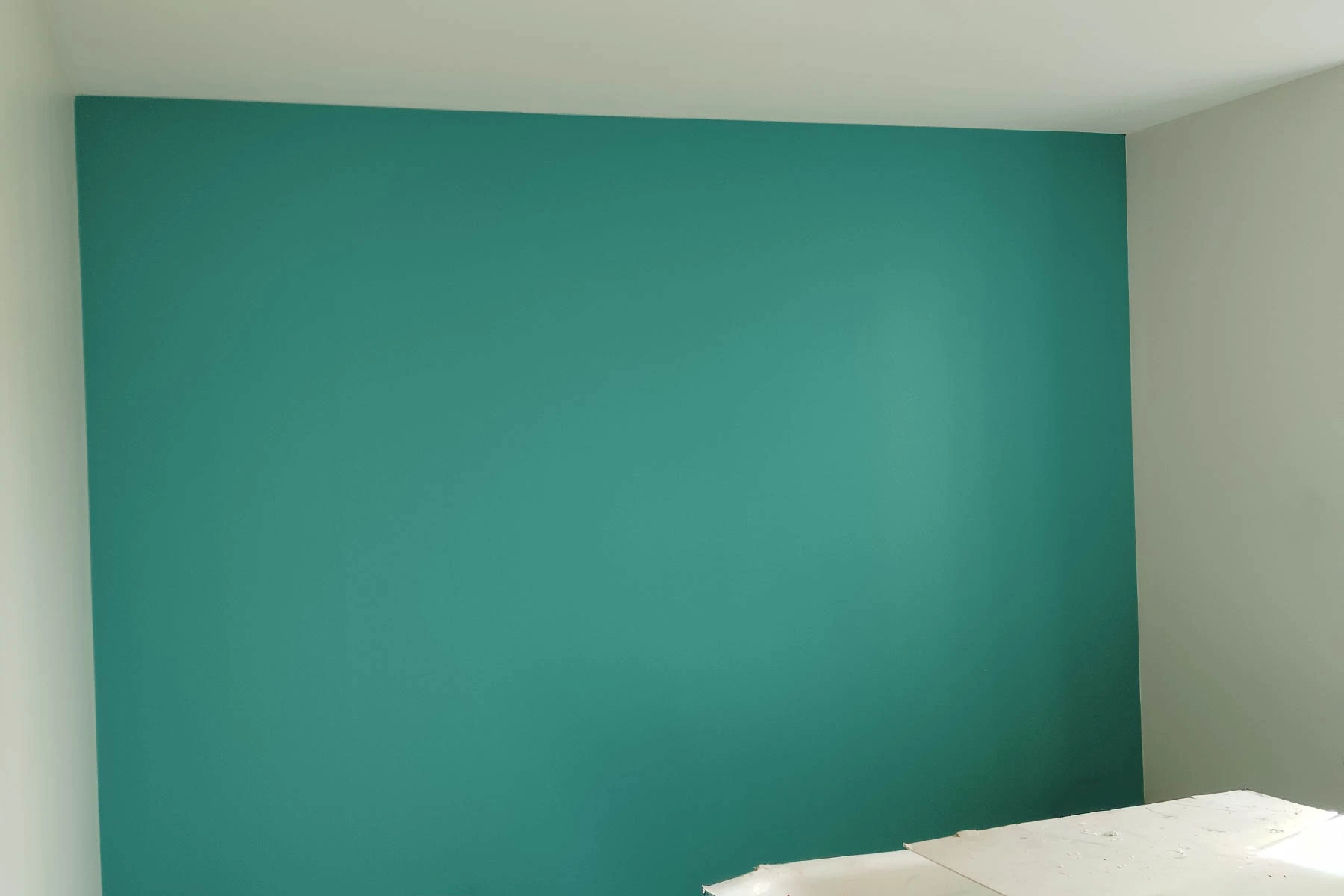 Application soignée d'une peinture intérieure de couleur moderne avec finition mate sur un mur de pièce de vie par un artisan peintre à Nancy